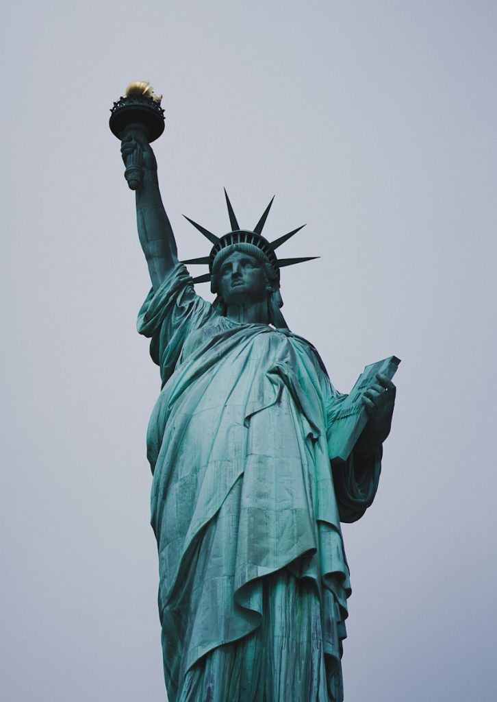 the statue of liberty is shown against a gray sky