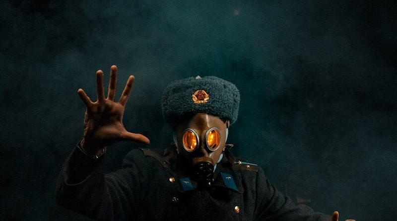 a man wearing a gas mask and holding his hands up