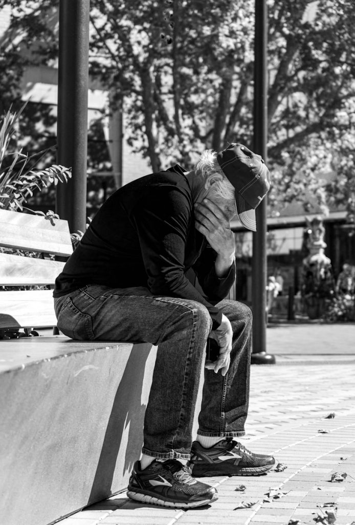 man in black jacket and pants sitting on bench